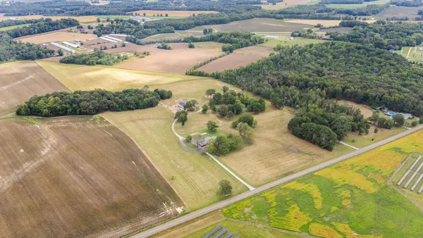 a front view of house with yard and trees in the background