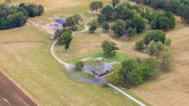 a front view of house with yard and trees in the background