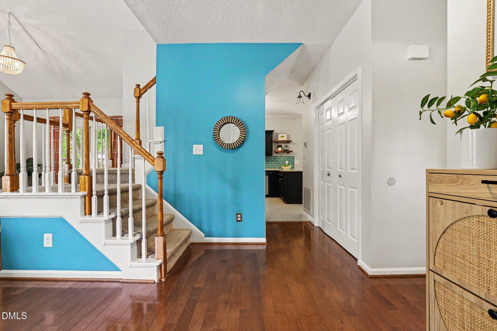 5468 Ingate Way Raleigh, NC 27613 - Photo 3 of 24 a view of a hallway with wooden floor and staircase