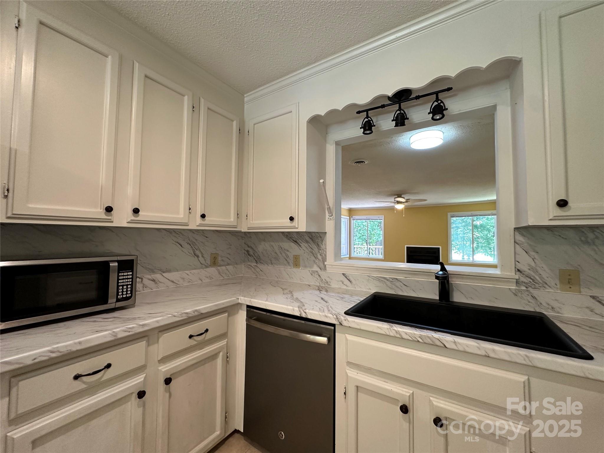 1590 Springpoint Road, Unit B Rock Hill, SC 29732 - Photo 15 of 39 a kitchen with a sink dishwasher and white cabinets with wooden floor