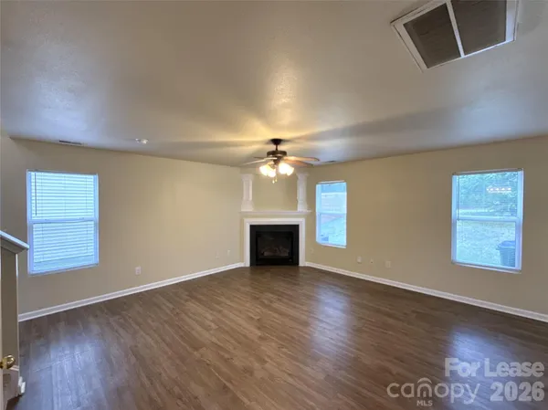 an empty room with windows and a fireplace
