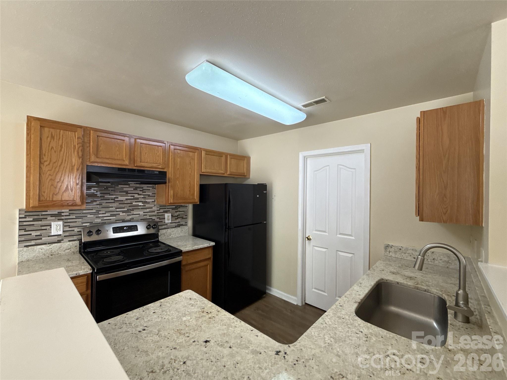 6831 Sunman Road Charlotte, NC 28216 - Photo 6 of 14 a kitchen with a refrigerator sink and stove