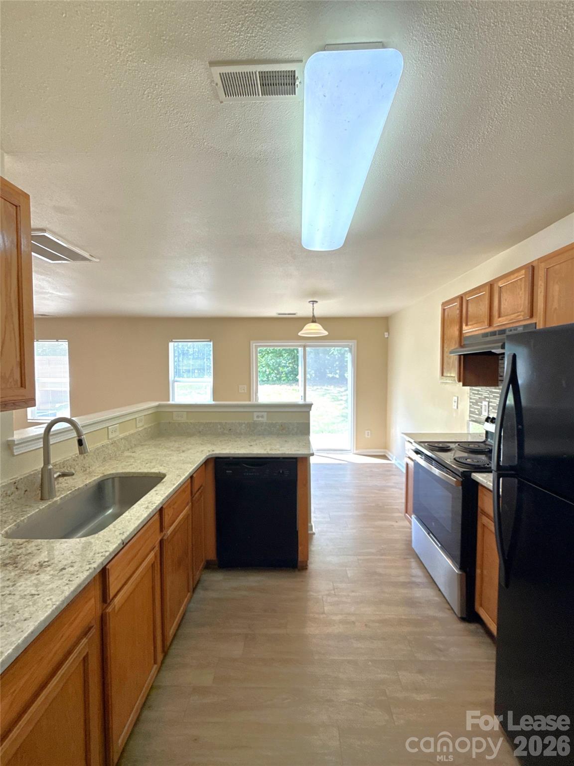 6831 Sunman Road Charlotte, NC 28216 - Photo 7 of 14 a kitchen with stainless steel appliances granite countertop a sink and a refrigerator