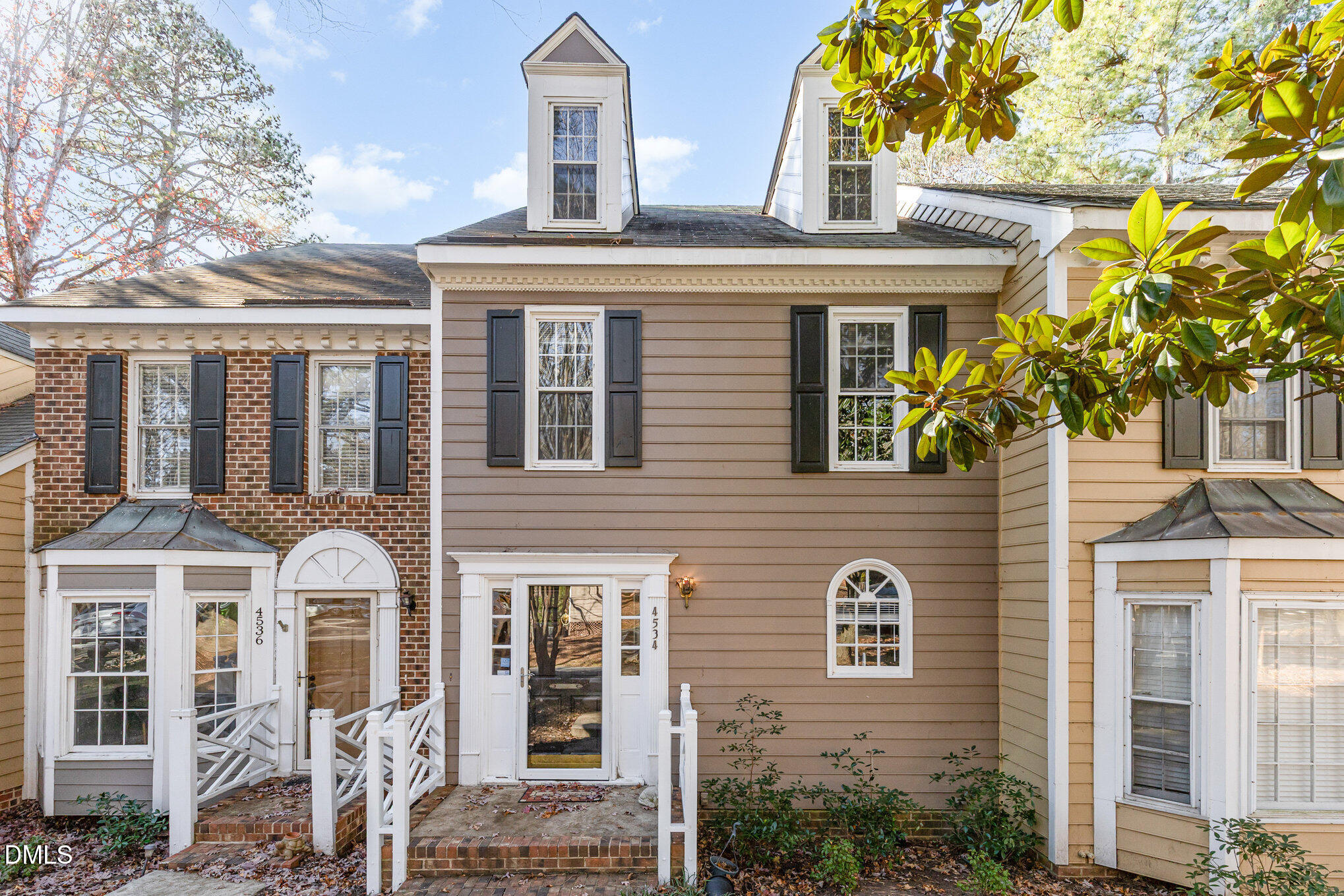 a front view of a house with a tree