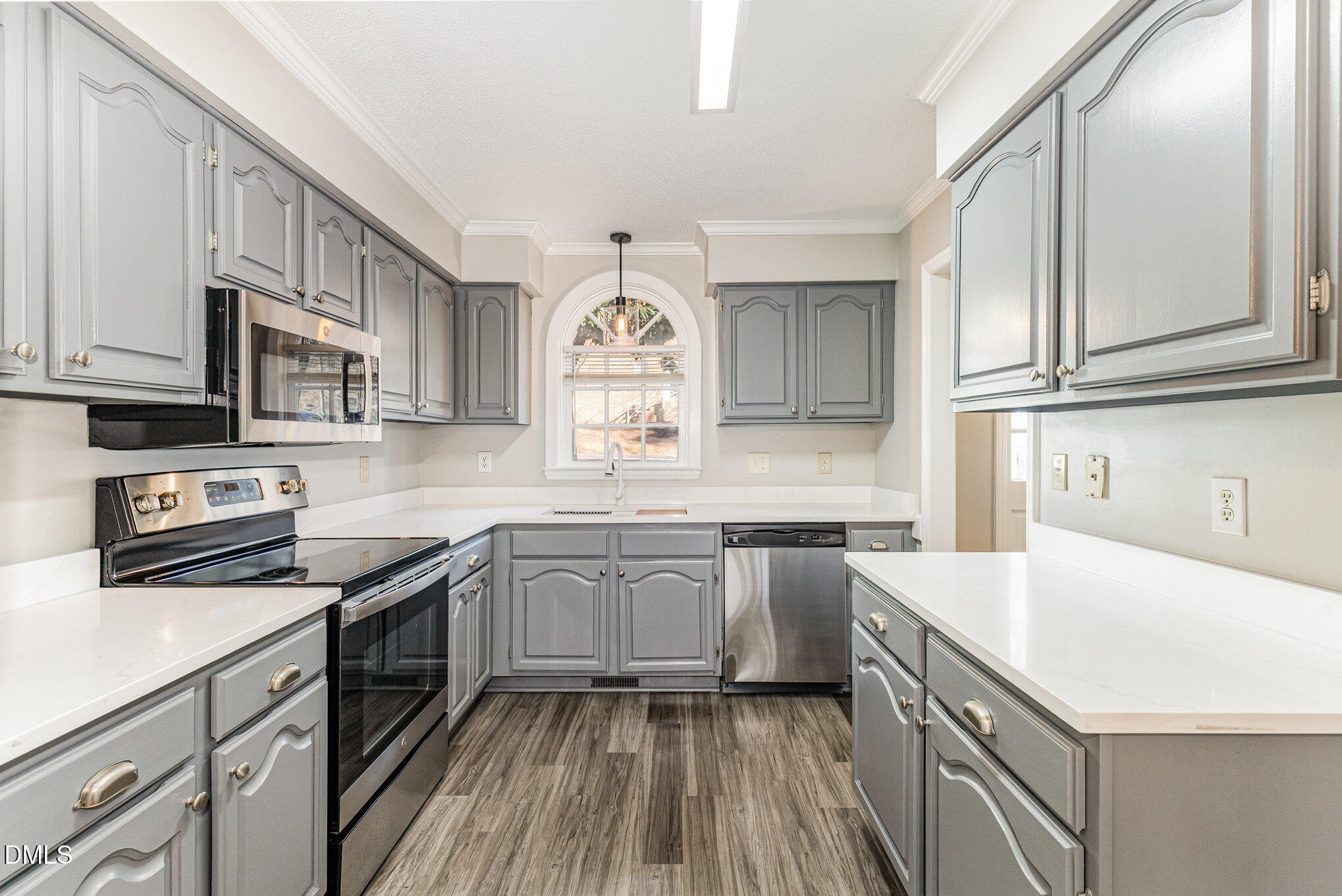 4534 Hamptonshire Drive Raleigh, NC 27613 - Photo 11 of 27 a kitchen with stainless steel appliances granite countertop a sink dishwasher stove and white cabinets with wooden floor