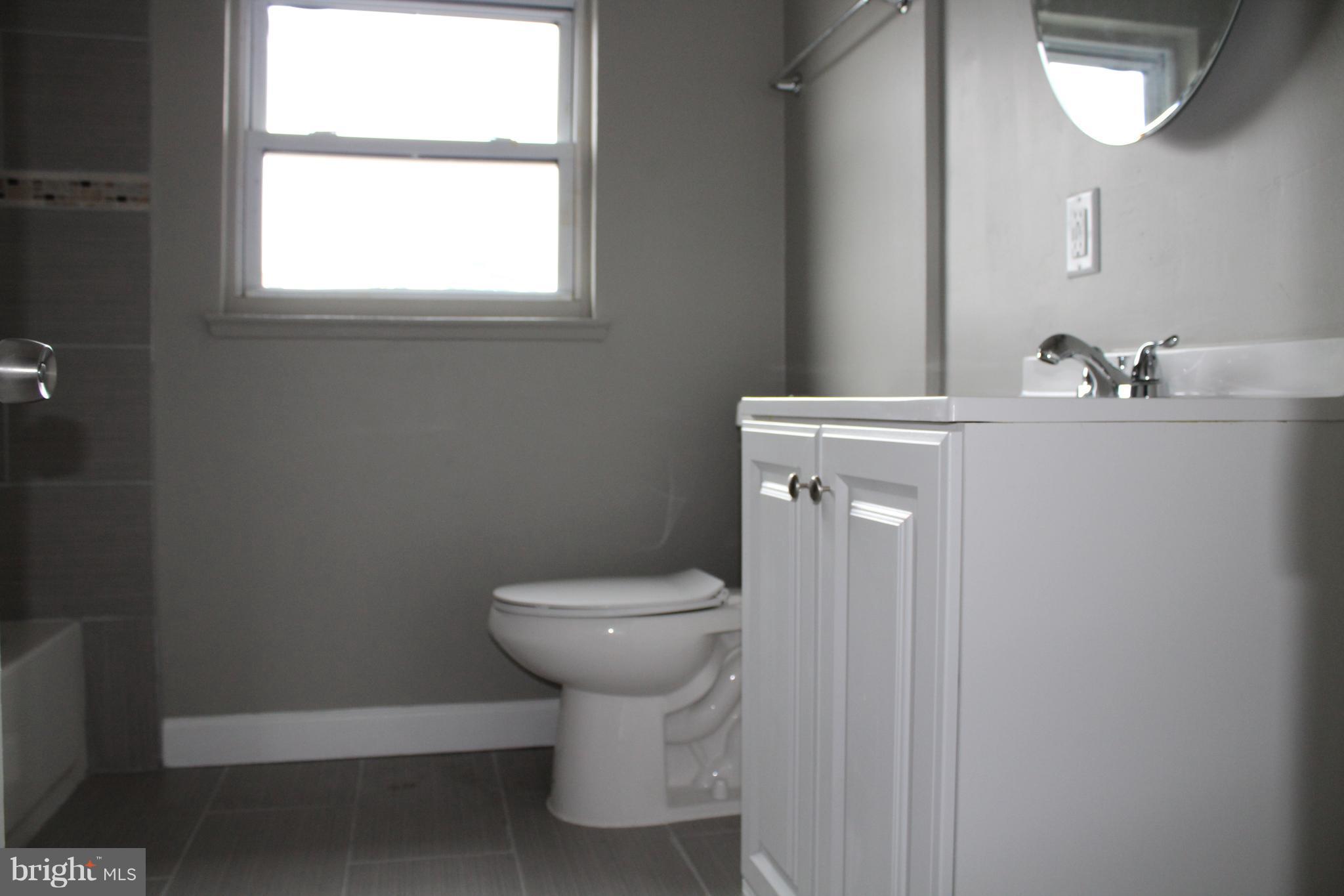 650 Queensgate Road Baltimore, MD 21229 - Photo 17 of 25 a bathroom with a toilet sink and mirror