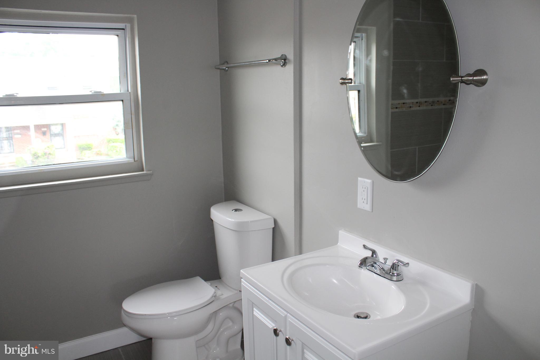 650 Queensgate Road Baltimore, MD 21229 - Photo 18 of 25 a bathroom with a toilet sink and mirror