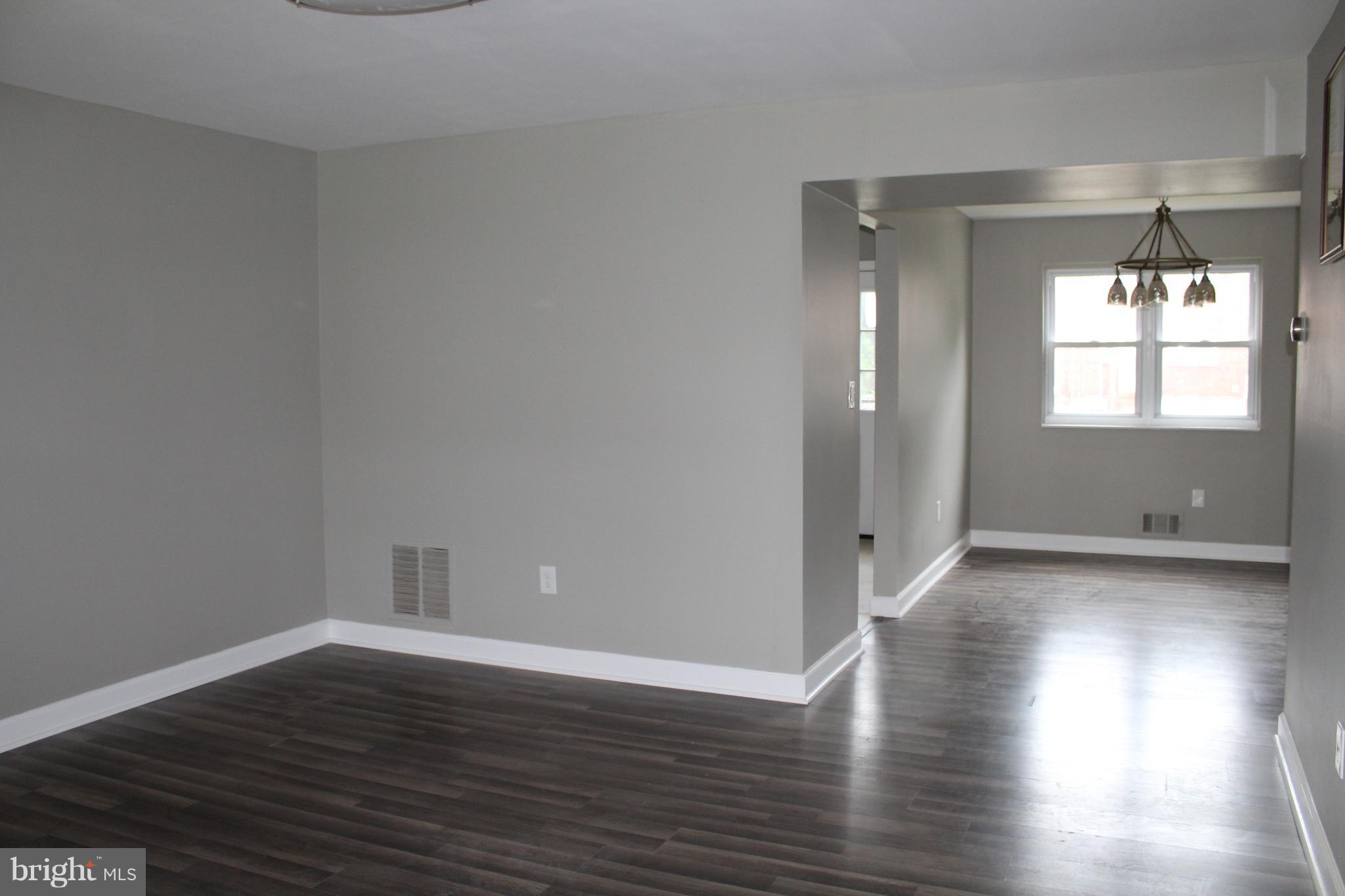 650 Queensgate Road Baltimore, MD 21229 - Photo 4 of 25 an empty room with wooden floor and windows