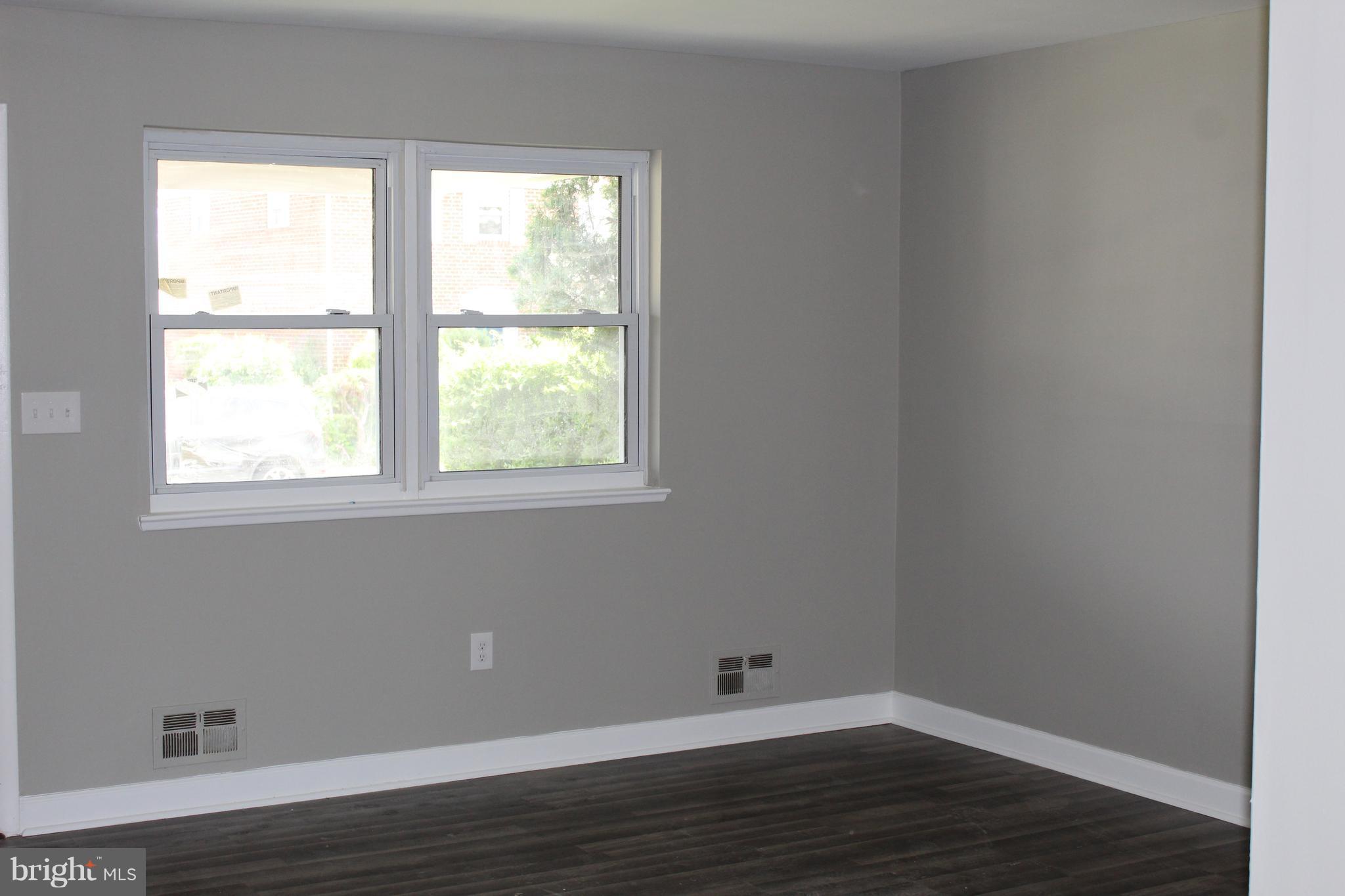 650 Queensgate Road Baltimore, MD 21229 - Photo 5 of 25 a view of an empty room with wooden floor and a window