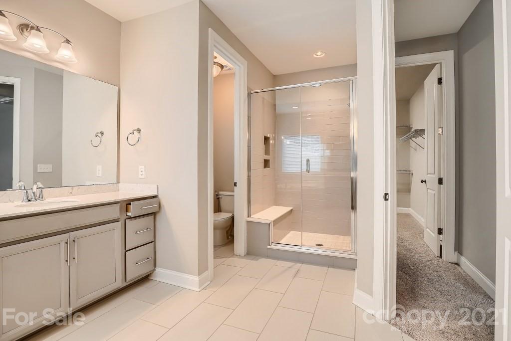 942 Emory Lane Fort Mill, SC 29708 - Photo 21 of 33 a bathroom with a granite countertop sink mirror and a shower