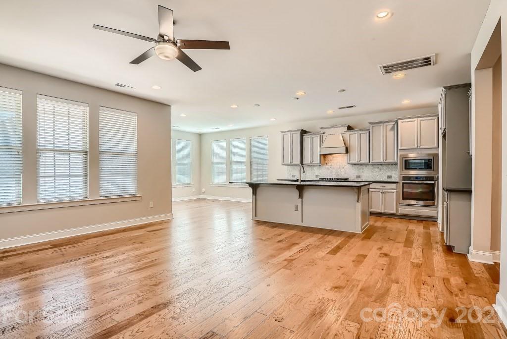 942 Emory Lane Fort Mill, SC 29708 - Photo 6 of 33 a large kitchen with stainless steel appliances kitchen island a large counter space and wooden floors