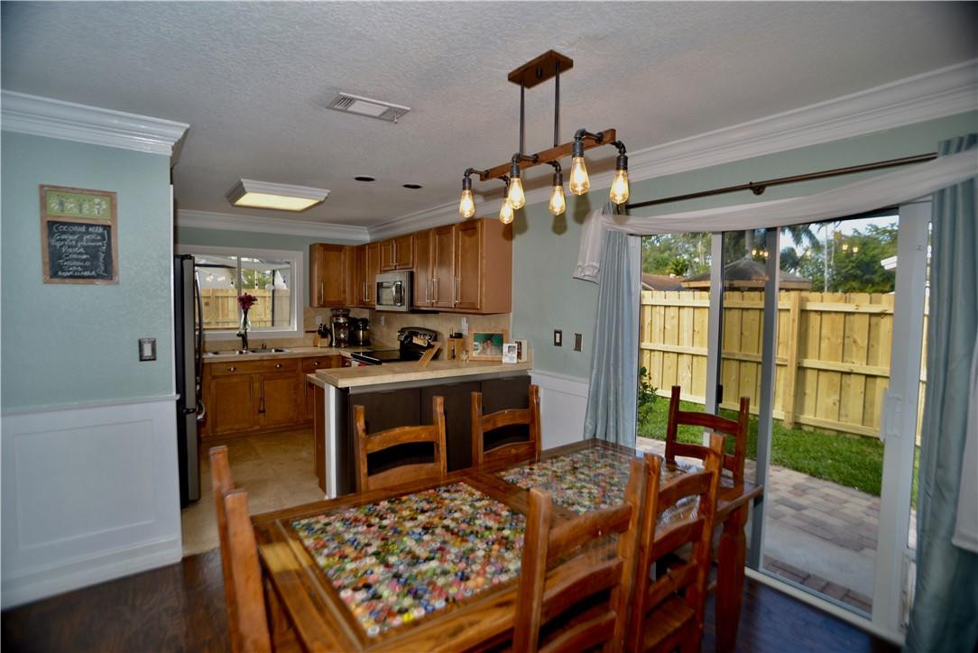9812 Spanish Isles Drive Boca Raton, FL 33496 - Photo 12 of 44 a view of a dining room with furniture a chandelier and wooden floor