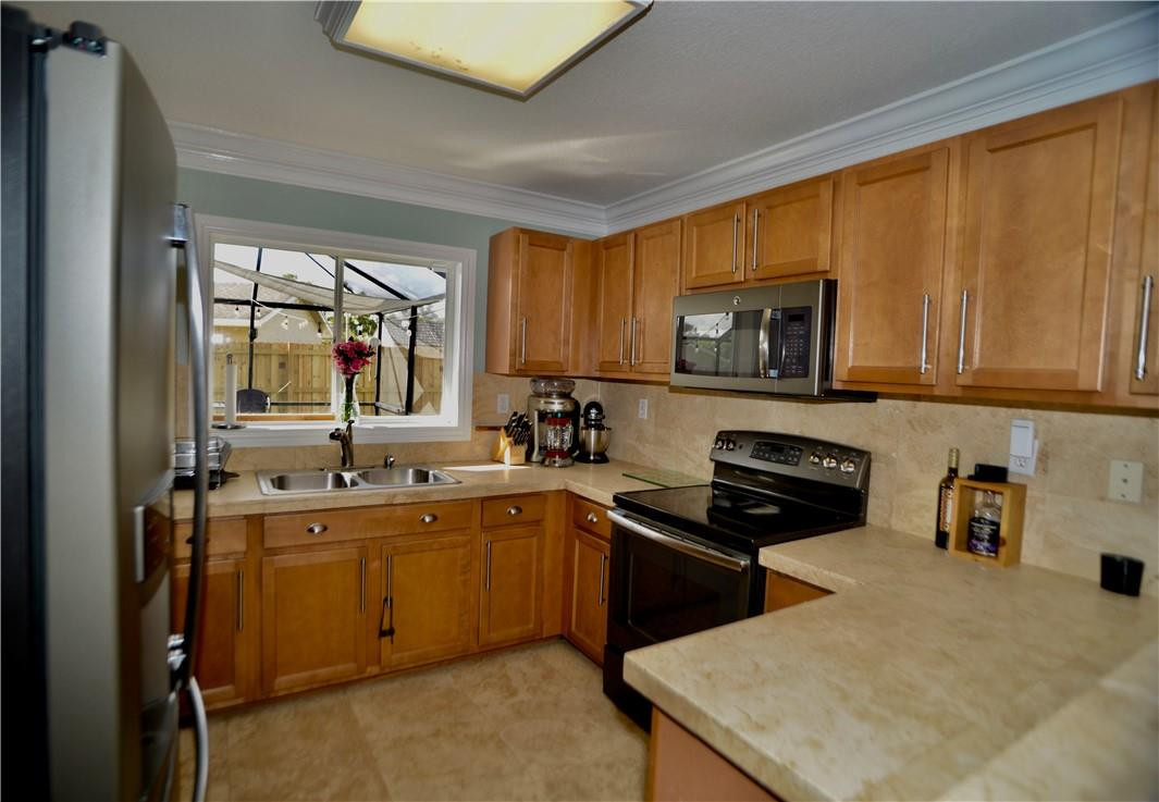 9812 Spanish Isles Drive Boca Raton, FL 33496 - Photo 13 of 44 a kitchen with stainless steel appliances a stove sink microwave and refrigerator