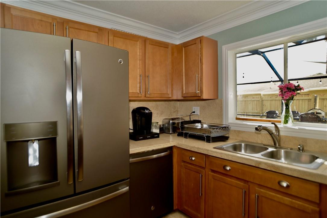 9812 Spanish Isles Drive Boca Raton, FL 33496 - Photo 15 of 44 a kitchen with a sink a refrigerator and cabinets