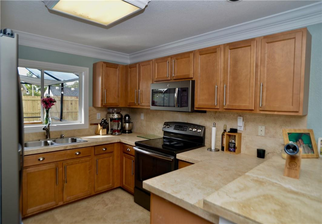 9812 Spanish Isles Drive Boca Raton, FL 33496 - Photo 16 of 44 a kitchen with stainless steel appliances granite countertop a sink stove and microwave