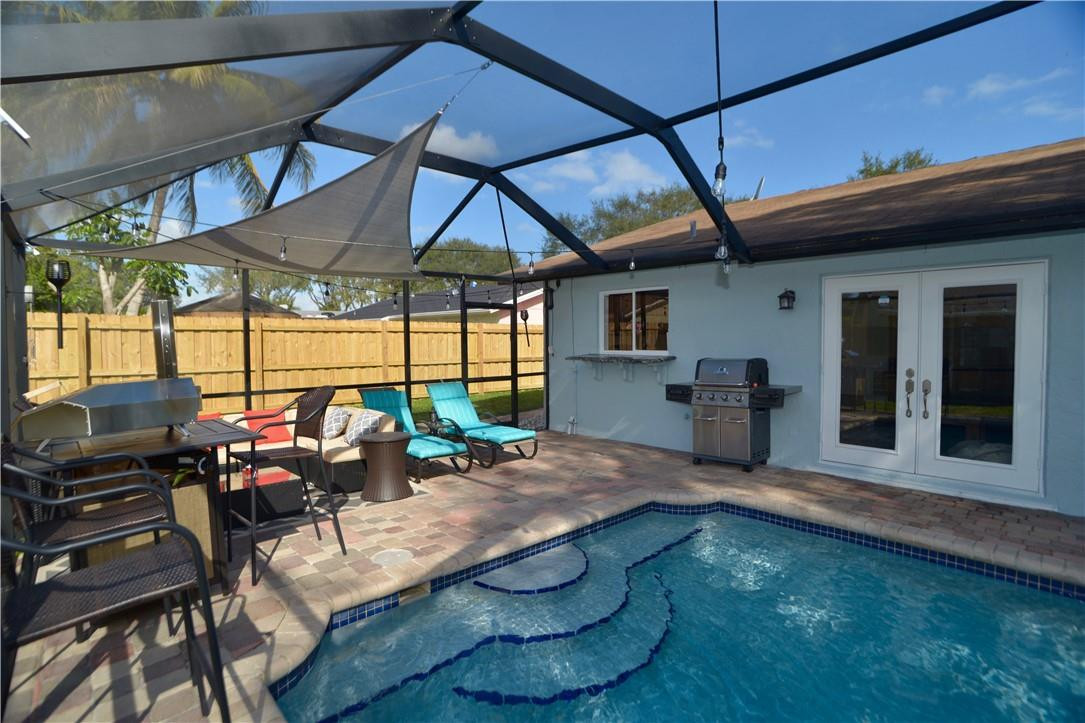 9812 Spanish Isles Drive Boca Raton, FL 33496 - Photo 40 of 44 a view of a patio with table and chairs under an umbrella