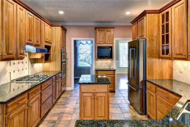a kitchen with stainless steel appliances granite countertop a refrigerator and a stove