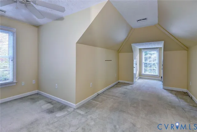 an empty room with windows and cabinet