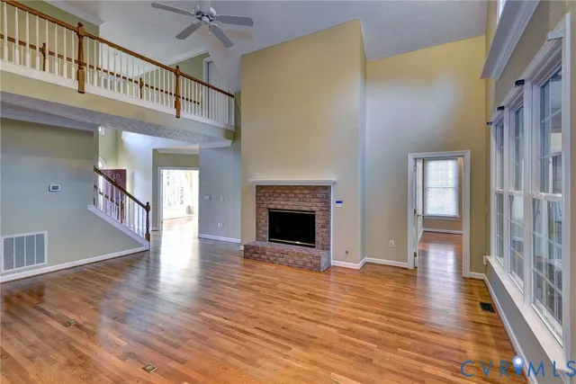 a view of a livingroom with wooden floor and a kitchen space