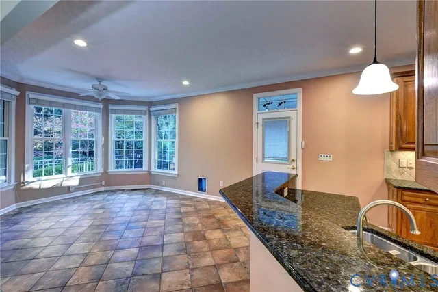 a view of a kitchen with granite countertop a sink and a large window