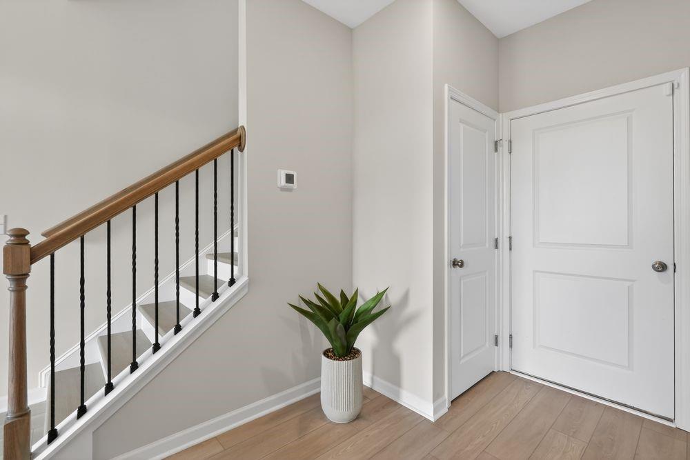 747 Meadow Ridge Lane Cumming, GA 30040 - Photo 7 of 41 a view of a hallway with wooden floor and a potted plant