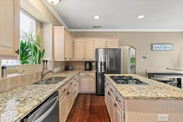 a kitchen with a granite countertop sink stove and refrigerator