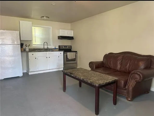 a living room with furniture and a refrigerator