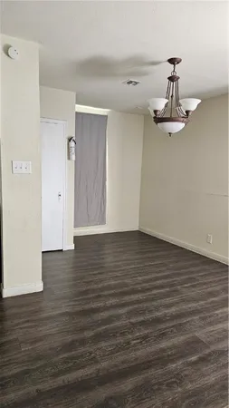 a view of a room with wooden floor and white walls