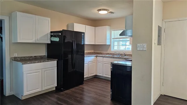 a kitchen with a refrigerator and a stove top oven