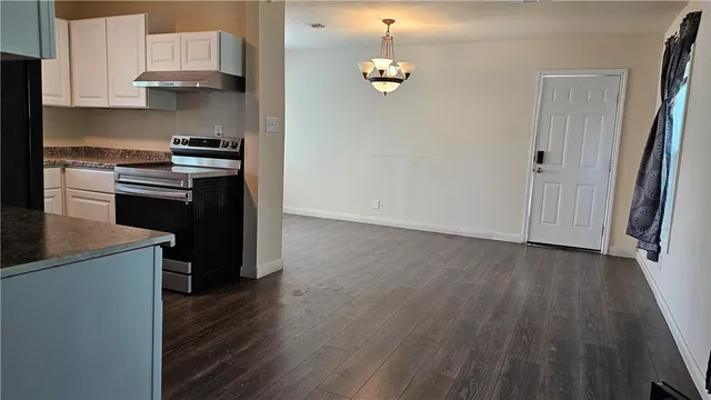 an empty room with wooden floor and cabinets