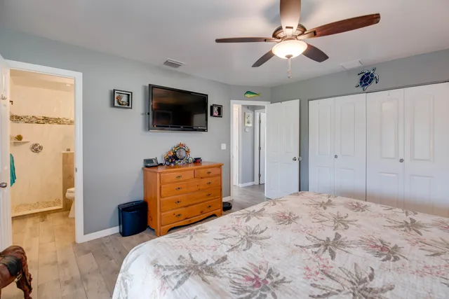 a bedroom with a bed a flat screen tv and a dresser