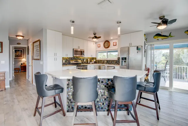 a dining room with stainless steel appliances kitchen island a table and chairs