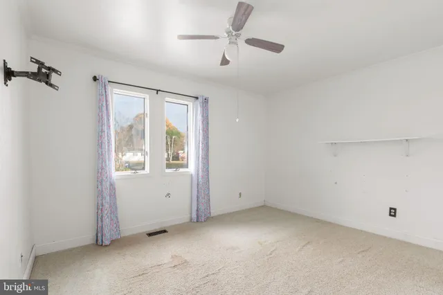 a view of room with a ceiling fan and window