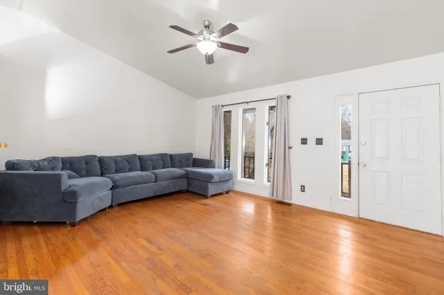 a living room with furniture and a ceiling fan