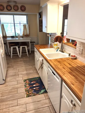 a kitchen with kitchen island granite countertop a sink stove and cabinets