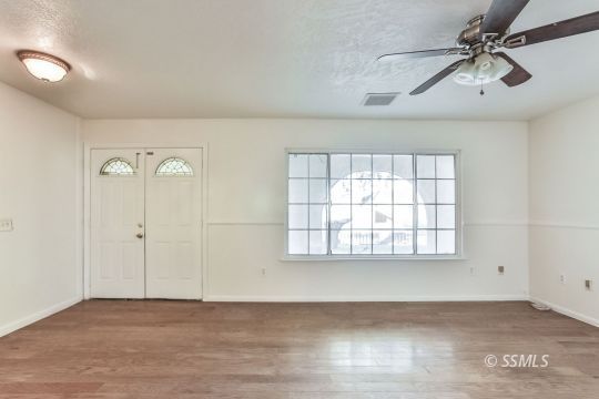 712 South Alvord Street Ridgecrest, CA 93555 - Photo 4 of 33 wooden floor in an empty room with a window