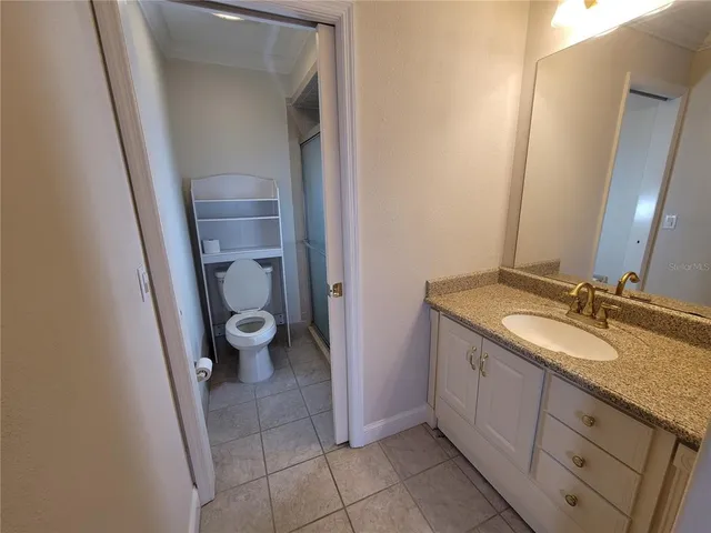 a view of an empty room with a window and a kitchen