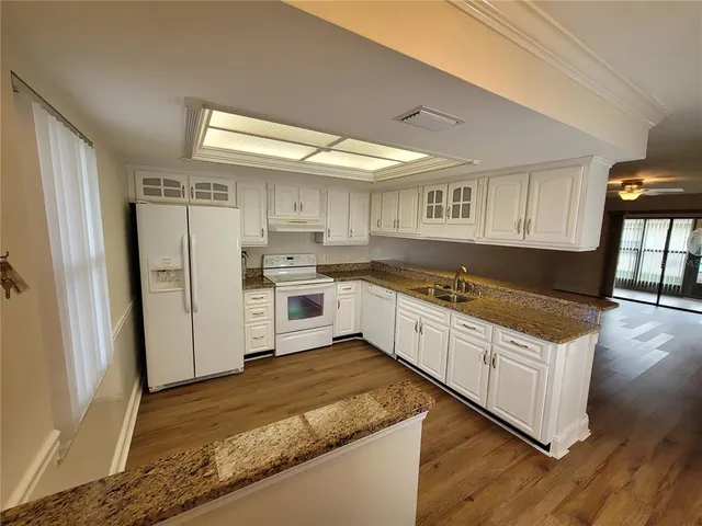 a kitchen with granite countertop white cabinets and white appliances