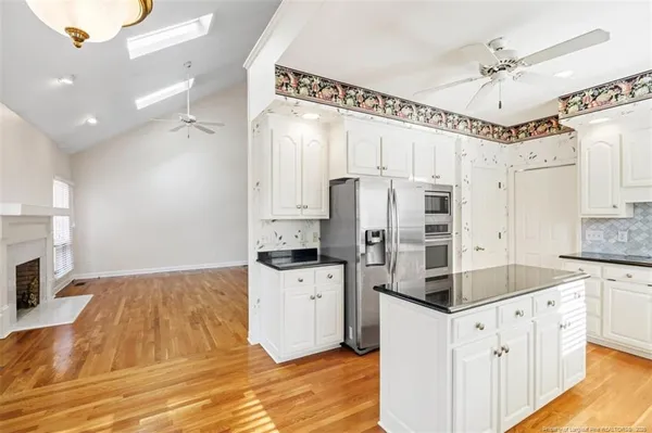 a kitchen with cabinets and wooden floor