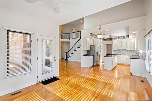 a view of a living room and kitchen view with wooden floor