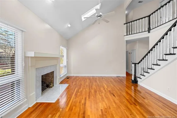 a view of empty room with wooden floor and fireplace