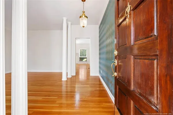 a view of a hallway with wooden floor and staircase
