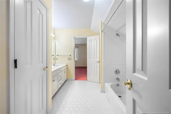 a bathroom with a tub sink and mirror