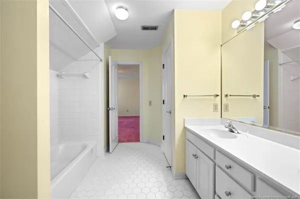 a bathroom with a bathtub shower sink vanity and a mirror