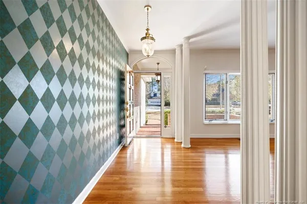 a view of a hallway with wooden floor and windows