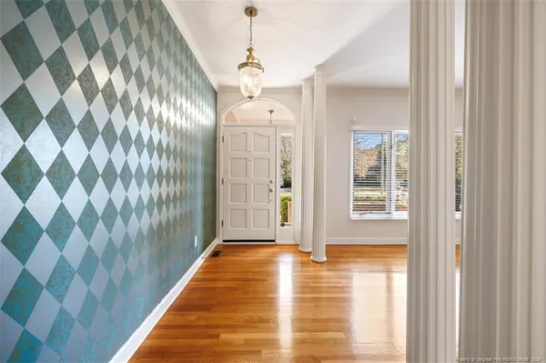 a view of a hallway with windows and chandelier