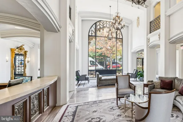 a living room with furniture a fireplace and a chandelier