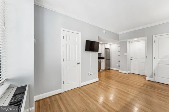 a view of empty room with wooden floor