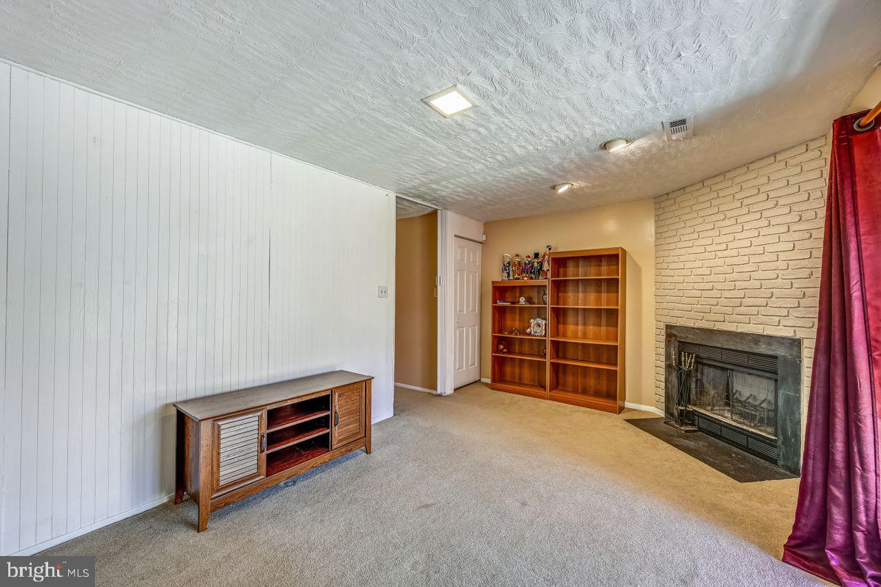 355 Rambling Ridge Court Pasadena, MD 21122 - Photo 23 of 28 a view of an empty room with a fireplace and a window