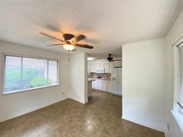 a view of a livingroom with a ceiling fan and window